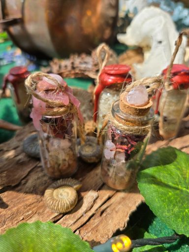 Bouteilles en verre entourées de lierre et d'éléments naturels, sur un fond en bois.