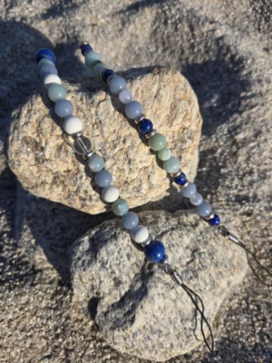 Bracelet en perles colorées sur des pierres grises.