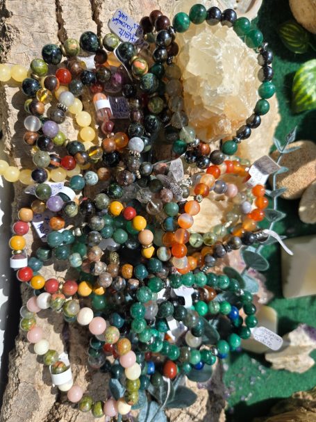 Collier en perles colorées disposés autour de cristaux sur une surface texturée.