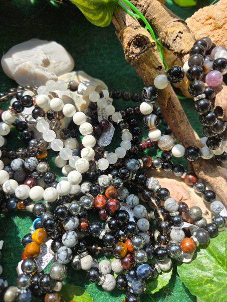 Un assortiment de bracelets en perles colorées sur un fond vert.