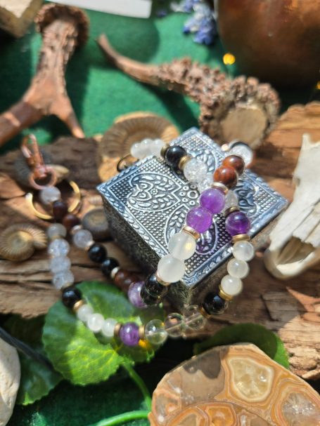 Bracelet coloré en pierre avec des motifs sur une boîte décorative en métal.