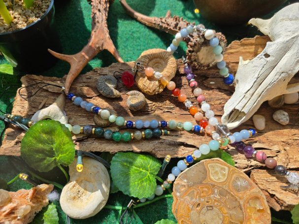 Assortiment de colliers en pierres semi-précieuses sur un fond naturel.